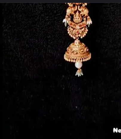 A gold jhumka with pearl drop on black, from their newly launched jade line