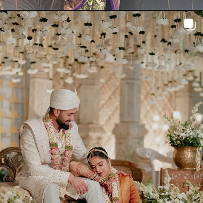 A groom and bride under a white mandap, dressed by the shop
